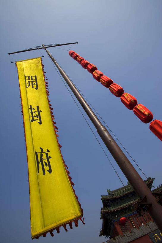 无人,公园,竖图,室外,白天,仰视,旅游,度假,名胜古迹,标志建筑,地标,建筑,旗帜,照明,中国,亚洲,吊挂,悬挂,阴影,遗迹,光线,标志,灯笼,文字,影子,纸灯笼,字符,墙,挂,古迹,文物,娱乐,标识,旗子,建设,城墙,古建筑,墙壁,墙面,黄色,红色,蓝色,蓝天,天空,阳光,灯具,天,享受,休闲,汉字,旅游胜地,放松,城楼,晴朗,坚硬,照亮,照明设备,中文,开封,防御,古文明,东亚,万里无云,中华人民共和国,国文,华文,门楼,旌旗,旗号,河南,河南省,豫,华中地区,开封市,坚固,晴空,晴空万里,彩图,低角度拍摄,龙亭区,清明上河园