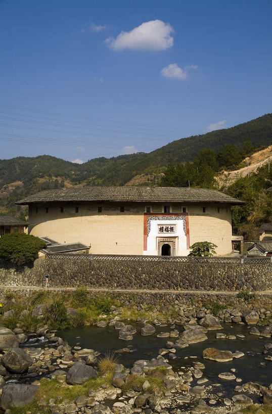 无人,家,竖图,室外,白天,正面,旅游,度假,名胜古迹,山,山脉,植物,门,标志建筑,地标,建筑,中国,亚洲,阴影,遗迹,光线,瓦片,影子,房屋,墙,屋顶,屋檐,屋子,山峰,云,云朵,山峦,云彩,顶棚,古迹,文物,娱乐,建设,古建筑,楼房,檐,墙壁,墙面,住宅,树,树木,蓝色,绿色,白云,蓝天,天空,阳光,自然,门框,群山,天,享受,休闲,旅游胜地,放松,生长,晴朗,成长,福建,古文明,东亚,土楼,福建省,永定县,中华人民共和国,华东地区,闽,龙岩,龙岩市,晴空,彩图,房子,福建土楼,客家土楼,客家土围楼,圆形围屋,永定土楼