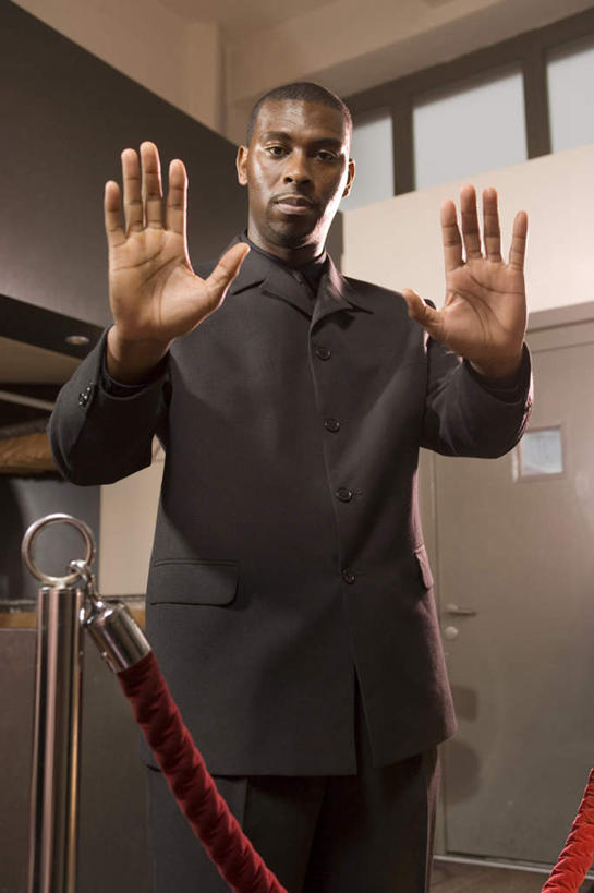 西方人,秃头,一个人,警卫,栏杆,站,举,笑,微笑,竖图,室外,白天,仰视,聚会,奢侈,夜生活,欧洲,非洲,黑人,欧洲人,仅一个男性,仅一个人,仅一个中年男性,墙,围栏,注视,娱乐,护栏,墙壁,墙面,红色,观察,看,托,站着,休闲,放松,观看,夜店,察看,关注,夜总会,保镖,保镳,男人,男性,中年男性,非洲人,光头,无发,举起,举手,举着,向上举,向上伸,向上托,站立,半身,彩图,低角度拍摄,挂绳礼宾杆,栏杆柱,礼宾带,礼宾杆,礼宾杆围栏,礼宾栏,礼宾绳,礼宾柱