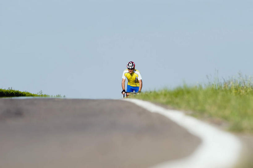 一个人,横图,室外,白天,正面,运动服,锻炼,旅游,度假,运动,太阳,道路,路,公路,自行车,帽子,仅一个男性,仅一个人,弯腰,阴影,服装,光线,头盔,影子,旷野,田野,交通,娱乐,踩,车,脚踏车,仅一个年轻男性,衣服,阳光,安全帽,交通工具,踩着,驾驶,行驶,享受,休闲,放松,服饰,操纵,控制,载具,原野,室外运动,户外运动,操控,弯身,把持,男人,男性,年轻男性,马路,半身,彩图,健身,运动装