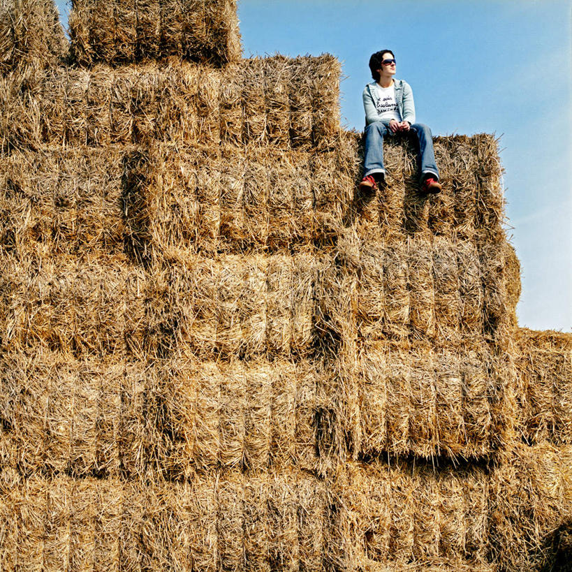 西方人,一个人,坐,方图,室外,白天,仰视,欧洲,欧洲人,仅一个年轻女性,仅一个女性,仅一个人,阴影,服装,光线,墨镜,眼镜,影子,草堆,干草,注视,休闲装,娱乐,衣服,蓝色,蓝天,天空,阳光,太阳镜,太阳眼镜,天,观察,看,享受,休闲,休闲服,遮阳镜,放松,服饰,晴朗,观看,察看,关注,万里无云,年轻女性,女人,女性,白种人,晴空,晴空万里,坐着,彩图,低角度拍摄,全身
