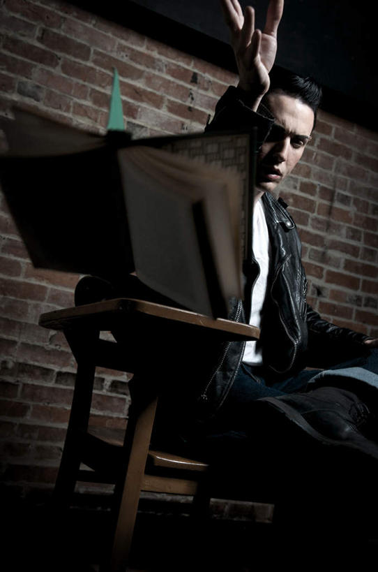 西方人,一个人,坐,举,竖图,室内,白天,正面,书籍,椅子,欧洲,欧洲人,仅一个男性,仅一个人,一本,服装,墙,休闲装,墙壁,墙面,仅一个年轻男性,衣服,会议椅,打开,翻开,托,休闲,休闲服,服饰,办公椅,皮夹克,商务椅,培训椅,掀开,男人,男性,年轻男性,白种人,书,图书,举起,举手,举着,向上举,向上伸,向上托,坐着,半身,彩图