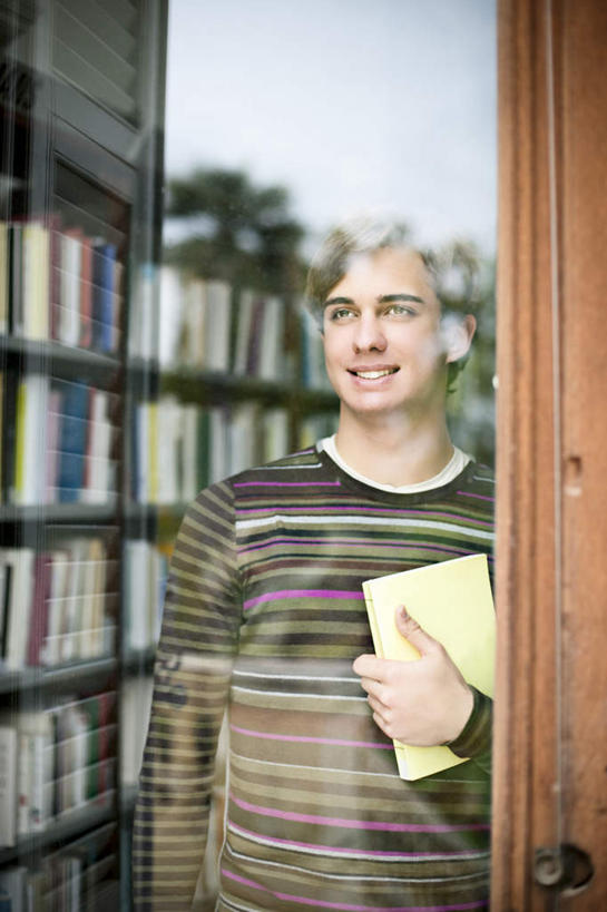 西方人,一个人,图书馆,站,笑,微笑,露齿笑,竖图,室外,白天,正面,看书,阅读,窗户,书籍,欧洲,欧洲人,仅一个男性,仅一个人,眺望,握,学习,远眺,服装,拿,拿着,远望,注视,休闲装,玻璃窗,仅一个年轻男性,衣服,书本,观察,看,站着,休闲,休闲服,读书,浏览,握着,服饰,观看,遥望,察看,关注,浏览室,了望,远瞩,男人,男性,年轻男性,白种人,书,图书,站立,半身,彩图,书库,图书库,阅览室