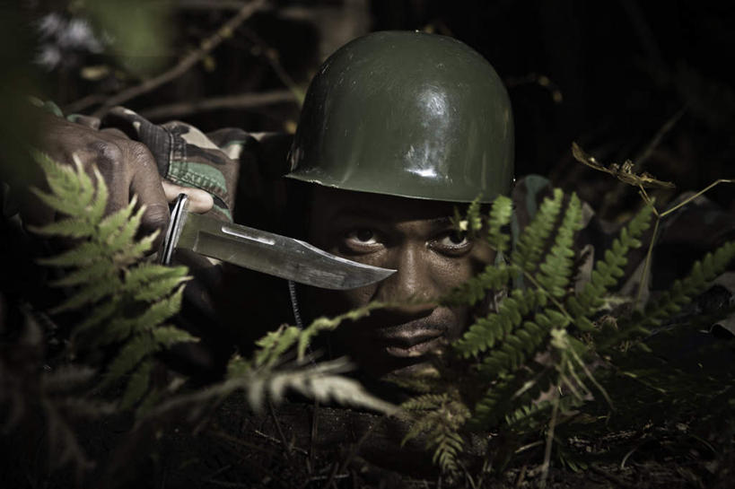 西方人,一个人,横图,室外,夜晚,正面,制服,竞争,植物,欧洲,非洲,黑人,欧洲人,仅一个男性,仅一个人,对抗,握,冲突,枝条,刀具,拿,拿着,破坏,树,树木,树枝,仅一个年轻男性,衣服,刀,武器,战争,握着,军人,损坏,军装,攻击,威胁,对立,矛盾,兵器,军服,潜伏,防御,敌对,挫败,斗争,抗拒,抗衡,凶器,杀伤,威慑,埋伏,虬枝,枝杈,危险,男人,男性,年轻男性,非洲人,半身,彩图,匕首