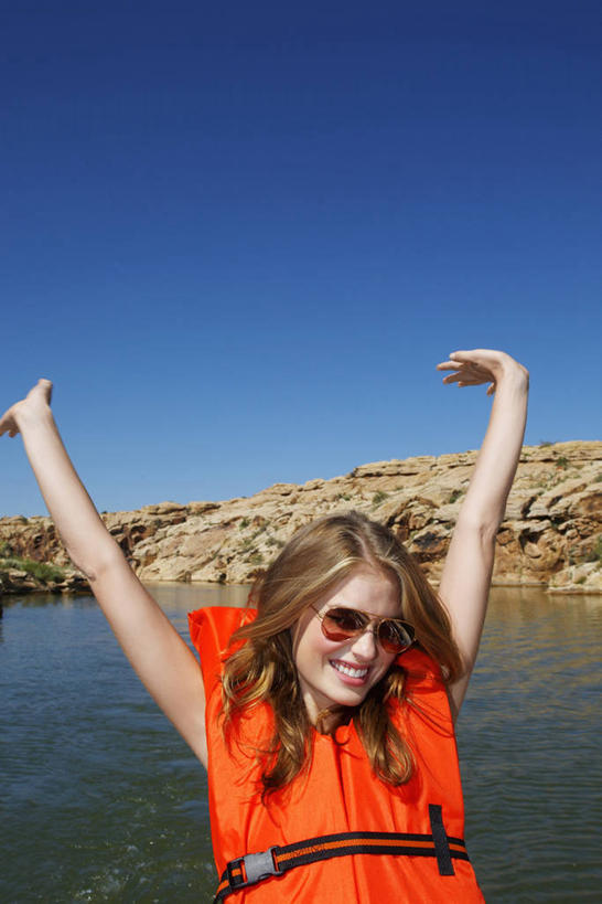 西方人,一个人,坐,举,笑,微笑,露齿笑,竖图,室外,白天,正面,湖,湖泊,石头,水,欧洲,欧洲人,仅一个年轻女性,仅一个女性,仅一个人,一副,阴影,波纹,光线,救生衣,墨镜,石子,眼镜,影子,湖面,水流,水面,涟漪,注视,蓝色,倒影,蓝天,水纹,天空,阳光,太阳镜,太阳眼镜,波浪,湖水,天,观察,看,托,橙色,遮阳镜,充气,晴朗,观看,救生背心,察看,倒映,救生,关注,万里无云,水晕,浮水衣,反照,年轻女性,女人,女性,白种人,石块,岩石,晴空,晴空万里,举起,举手,举着,向上举,向上伸,向上托,坐着,半身,彩图