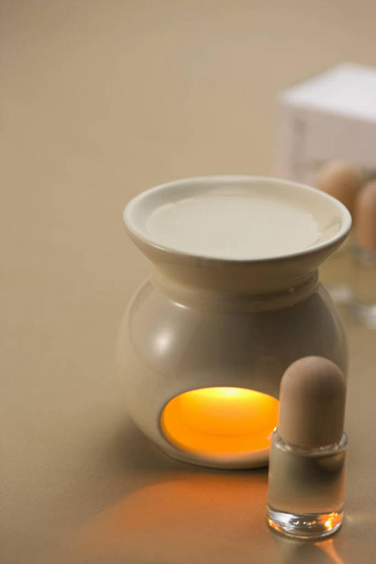 无人,竖图,俯视,室内,特写,白天,蜡烛,阴影,朦胧,模糊,反射,光线,火焰,影子,烛光,燃烧,精油,点燃,熏香炉,芳香植物,芳香油,挥发油,香精油,彩图,高角度拍摄,精油炉,香精炉,香熏炉,香薰炉