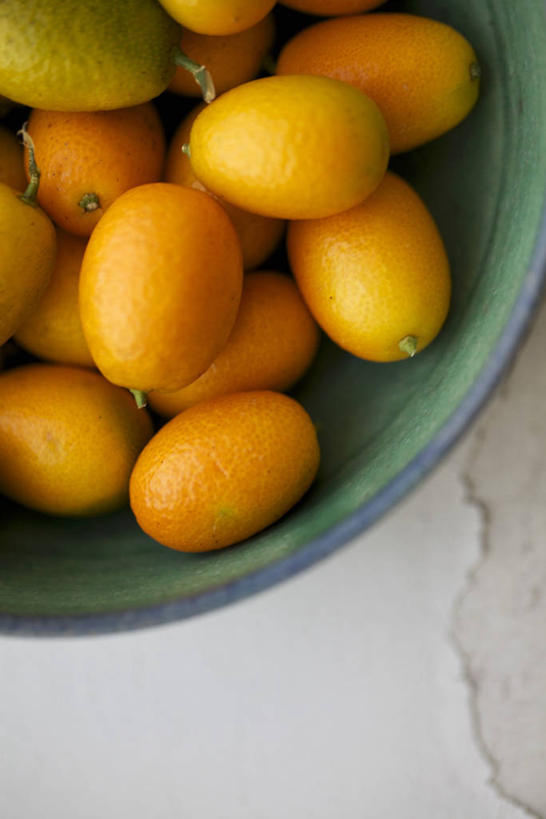 无人,竖图,俯视,室内,特写,白天,桌面,桌子,水果,一堆,许多,阴影,堆叠,堆积,新鲜,反射,木制,陶瓷,生食,食品,果实,陶瓷制品,食物,一个,木制品,容器,碗,橙色,金橘,金桔,有机食品,绿色食品,单个,储藏,堆,金弹,金柑,金枣,洋奶桔,储存,牛奶桔,彩图,高角度拍摄,贮存