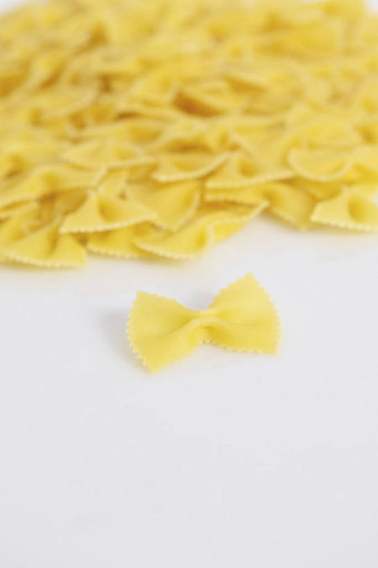 面食,面条,意大利面,无人,竖图,俯视,室内,特写,白天,白色背景,西餐,餐桌,桌子,一堆,许多,阴影,堆叠,堆积,反射,影子,面,料理,食品,食物,黄色,西式,摄影,影棚,餐台,堆,蝴蝶面,彩图,高角度拍摄,影棚拍摄,拍摄