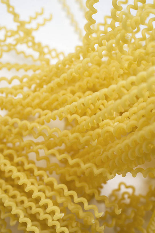 面食,面条,意大利面,无人,竖图,俯视,室内,特写,白天,西餐,桌面,桌子,一堆,许多,阴影,堆叠,堆积,反射,木制,影子,面,料理,食品,很多,食物,黄色,木制品,西式,堆,螺旋面,彩图,高角度拍摄