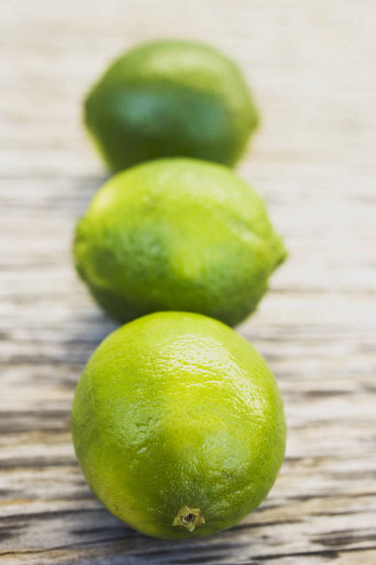 无人,竖图,俯视,室内,特写,白天,桌面,桌子,水果,一排,阴影,新鲜,整齐,反射,木制,影子,生食,食品,果实,食物,排列,三个,绿色,木制品,有机食品,绿色食品,队列,酸橙,代代,橙子,橙,彩图,高角度拍摄