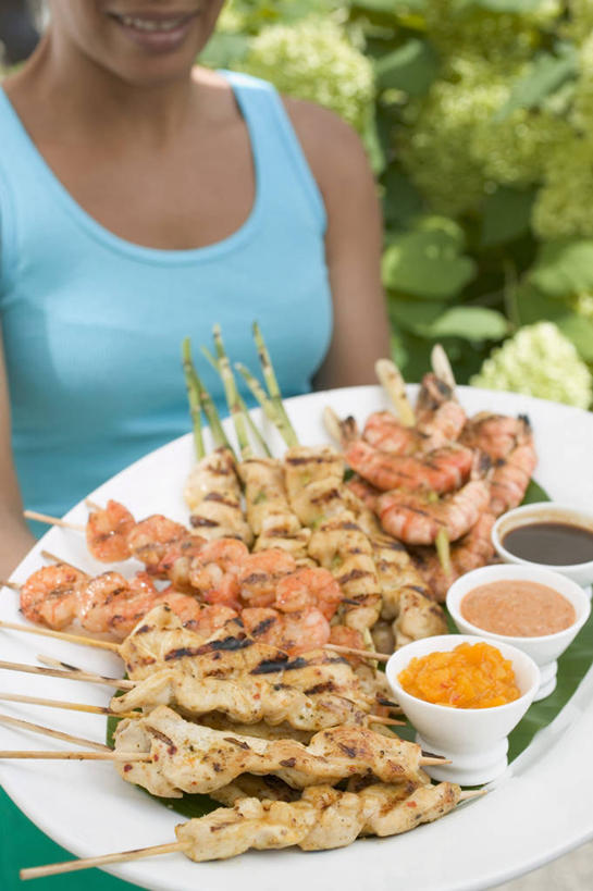 西方人,一个人,站,捧,笑,微笑,露齿笑,竖图,室外,白天,正面,烹饪,植物,餐具,欧洲,欧洲人,仅一个年轻女性,仅一个女性,仅一个人,服装,背心,碟子,盘,陶瓷,调料,酱料,酱汁,肉,佐料,料理,食品,陶瓷制品,烤肉,调味品,调味料,酱,菜肴,美食,肉类,树,树木,食物,衣服,绿色,自然,盘子,容器,碟,碗,站着,服饰,佳肴,生长,成长,储藏,衣着,储存,穿着,肉食,衣饰,印度菜,印度料理,年轻女性,女人,女性,白种人,端,端着,捧着,手捧,站立,半身,彩图,东南亚菜,沙嗲,沙嗲酱,印尼爪哇菜,贮存