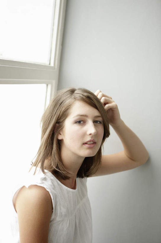 西方人,一个人,站,笑,微笑,竖图,室内,白天,正面,窗户,落地窗,欧洲,欧洲人,仅一个年轻女性,仅一个女性,仅一个人,服装,墙,扭头,注视,休闲装,玻璃窗,墙壁,墙面,衣服,白色,观察,看,靠,靠着,站着,转头,休闲,休闲服,服饰,观看,察看,关注,年轻女性,女人,女性,白种人,站立,半身,彩图