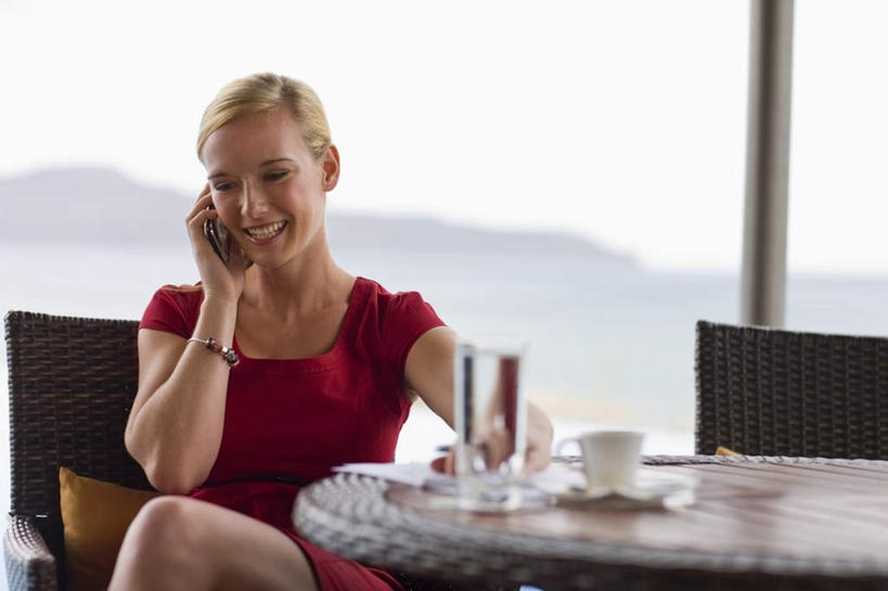 西方人,头发,一个人,坐,笑,打电话,微笑,露齿笑,横图,室外,白天,正面,裙子,山,水,餐桌,靠垫,桌面,桌子,杯子,电话,手机,椅子,欧洲,欧洲人,仅一个年轻女性,仅一个女性,仅一个人,握,连衣裙,瓷器,液体,木椅,庭院,山峰,院子,咖啡杯,靠枕,陶瓷制品,山峦,拿,拿着,注视,通讯设备,饮用水,玻璃制品,红色,天空,水杯,垫子,枕头,矿泉水,天,观察,看,金色,握着,餐台,观看,察看,关注,咖啡店,瓷杯,咖啡屋,蒸馏水,交流,年轻女性,女人,女性,白种人,玻璃杯,沟通,通话,坐着,半身,彩图,咖啡馆