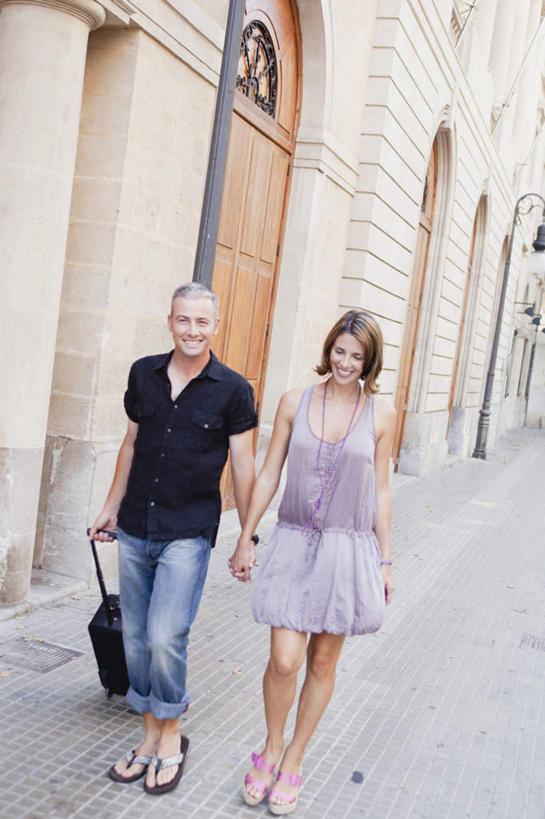 西方人,中年人,两个人,家庭,夫妻,家,走,拉,握手,笑,微笑,露齿笑,竖图,室外,白天,正面,裙子,T恤衫,爱情,道路,路,公路,欧洲,欧洲人,连衣裙,服装,裤子,拉杆箱,旅行箱,房屋,屋子,交通,浪漫,T恤,注视,牛仔裤,休闲装,楼房,住宅,衣服,紫色,行李箱,箱子,观察,看,休闲,温暖,温馨,一家人,休闲服,恩爱,恋人,服饰,观看,出差,和睦,察看,关注,男人,男性,女人,女性,中年男性,中年女性,白种人,夫妇,情侣,马路,步行,搀手,拉手,散步,手搀手,手拉手,手牵手,手握手,走路,彩图,全身,旅行,房子,伴侣,融洽