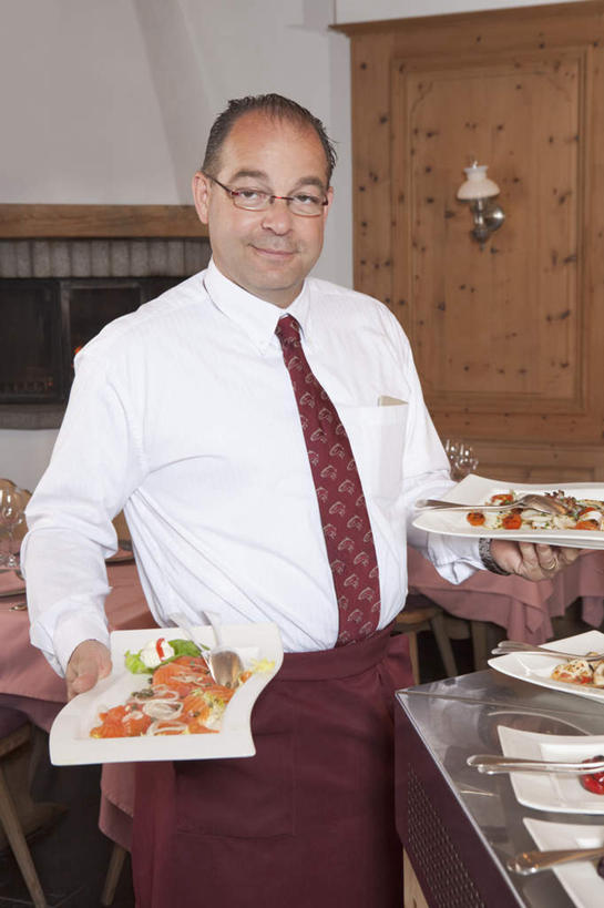 西方人,一个人,服务员,餐厅,站,捧,笑,微笑,露齿笑,竖图,室内,白天,正面,工作服,制服,烹饪,西餐,餐桌,桌子,餐具,欧洲,欧洲人,仅一个男性,仅一个人,仅一个中年男性,阴影,反射,碟子,盘,影子,墙,料理,食品,领带,注视,菜肴,美食,墙壁,墙面,食物,白色,盘子,碟,观察,看,站着,西式,佳肴,餐台,观看,察看,关注,工作制服,男人,男性,中年男性,白种人,服务生,侍者,端,端着,捧着,手捧,站立,半身,彩图,工作套服,餐馆,饭店,饭馆