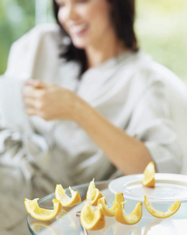 西方人,一个人,坐,笑,微笑,露齿笑,竖图,室内,白天,正面,餐桌,桌子,杯子,欧洲,欧洲人,仅一个年轻女性,仅一个女性,仅一个人,许多,握,服装,朦胧,模糊,瓷器,果皮,咖啡杯,陶瓷制品,很多,拿,拿着,注视,休闲装,衣服,灰色,观察,看,休闲,休闲服,握着,服饰,餐台,观看,察看,桔子皮,橘子皮,关注,瓷杯,年轻女性,女人,女性,白种人,坐着,半身,彩图