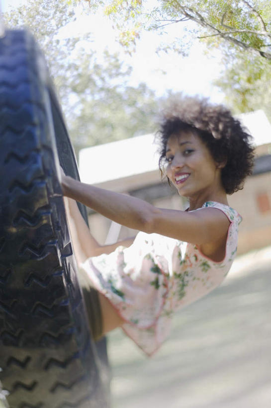 西方人,一个人,坐,笑,微笑,露齿笑,竖图,室外,白天,侧面,旅游,度假,树林,水,欧洲,非洲,黑人,欧洲人,仅一个人,服装,朦胧,模糊,水池,水塘,注视,休闲装,娱乐,树,树木,衣服,车轮,轮胎,荡秋千,扶,观察,看,享受,休闲,休闲服,抓,放松,服饰,观看,察看,抓着,抓住,扶着,关注,年轻女性,女人,女性,非洲人,卷发,玩耍,坐着,半身,彩图