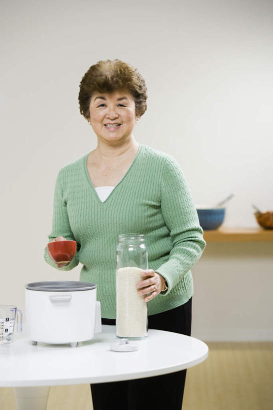 东方人,一个人,客厅,站,笑,微笑,露齿笑,竖图,室内,白天,正面,烹饪,桌面,桌子,厨具,亚洲,仅一个女性,仅一个人,握,服装,木制,电器,拿,拿着,注视,休闲装,黄种人,衣服,木制品,观察,看,站着,休闲,眯眼,休闲服,眯,握着,服饰,仅一个老年女性,观看,察看,家电,家用电器,关注,电饭锅,电饭煲,炊具,烹饪用具,电锅,老年女性,女人,女性,亚洲人,烹调用具,烹调,站立,半身,彩图,小家电