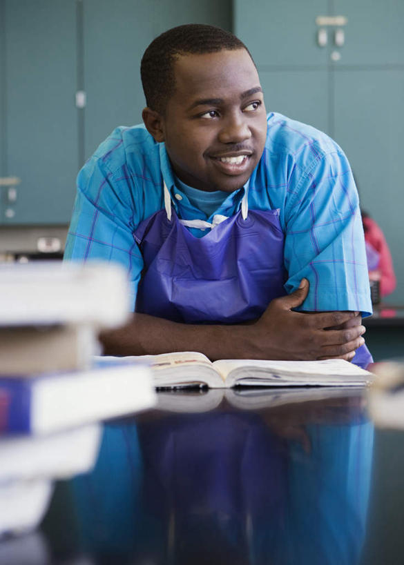 西方人,一个人,学校,站,笑,微笑,露齿笑,竖图,室内,白天,正面,桌子,书籍,欧洲,非洲,黑人,欧洲人,仅一个男性,仅一个人,撑,弯腰,服装,朦胧,模糊,围裙,扭头,注视,书桌,校园,仅一个年轻男性,衣服,课桌,观察,看,站着,转头,教室,服饰,观看,察看,撑着,衣着,白大褂,穿着,关注,实验服,弯身,衣饰,男人,男性,年轻男性,非洲人,书,图书,站立,半身,彩图,实验衣