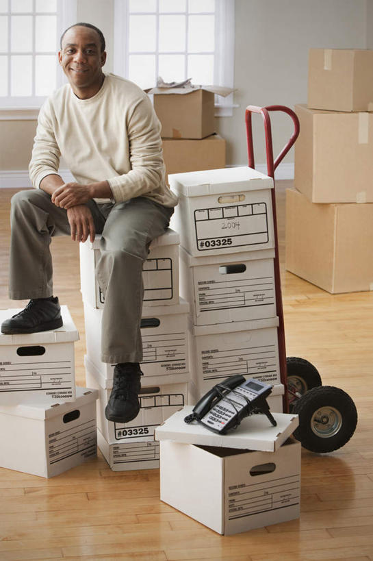 西方人,一个人,坐,笑,微笑,露齿笑,竖图,室内,白天,正面,欧洲,非洲,黑人,欧洲人,仅一个男性,仅一个人,仅一个中年男性,一堆,许多,阴影,堆叠,堆积,服装,反射,包装,影子,纸箱,注视,休闲装,衣服,容器,箱子,观察,看,休闲,休闲服,搭,服饰,观看,堆,搬家,察看,迁移,搭着,关注,纸板箱,包装箱,迁居,乔迁,搬迁,男人,男性,中年男性,非洲人,坐着,彩图,全身