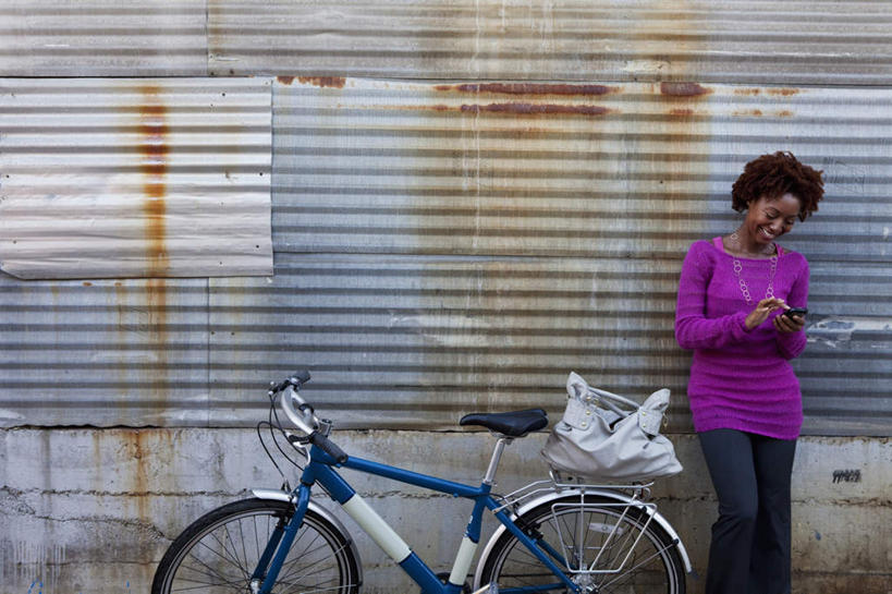 西方人,一个人,站,笑,打电话,微笑,露齿笑,横图,室外,白天,正面,自行车,电话,手机,欧洲,非洲,黑人,欧洲人,仅一个女性,仅一个人,一辆,握,阴影,服装,光线,影子,注视,休闲装,通讯设备,车,脚踏车,衣服,紫色,阳光,交通工具,低头,观察,看,站着,仅一个中年女性,休闲,休闲服,握着,服饰,观看,察看,关注,载具,一部,交流,女人,女性,中年女性,非洲人,沟通,通话,站立,半身,彩图