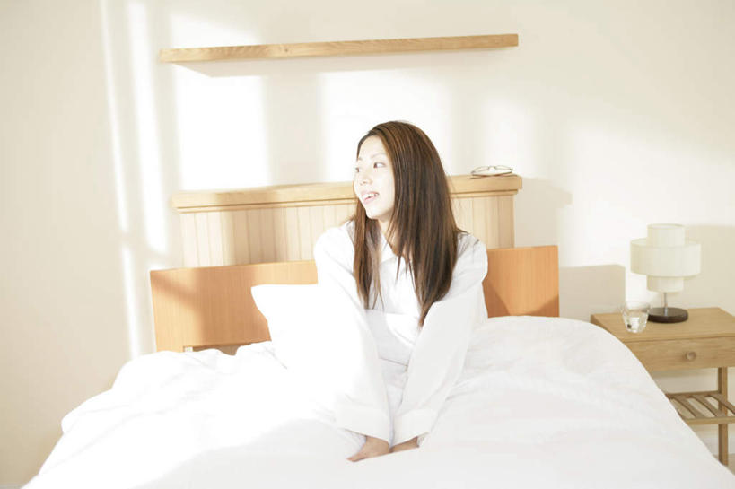 东方人,一个人,坐,笑,盘腿,微笑,露齿笑,横图,室内,白天,正面,床,靠垫,台灯,卧室,桌子,照明,亚洲,仅一个年轻女性,仅一个女性,仅一个人,阴影,睡衣,服装,反射,木制,影子,墙,灯光,床单,靠枕,茶几,扭头,注视,黄种人,被子,墙壁,墙面,灯,衣服,白色,木制品,灯具,垫子,枕头,观察,看,转头,服饰,单人床,观看,照亮,察看,被单,衣着,照明设备,穿着,关注,寝衣,衣饰,年轻女性,女人,女性,亚洲人,盘腿而坐,盘膝,盘着腿的,盘着腿坐,双腿交叉,坐着,彩图,全身,睡房,卧房