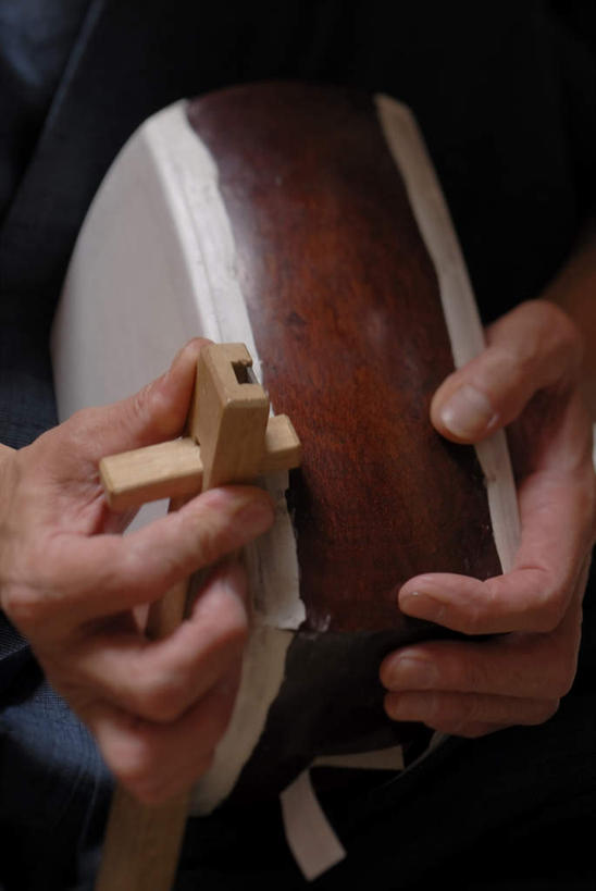 东方人,手,一个人,木匠,坐,竖图,室内,特写,白天,正面,工作服,制服,亚洲,双手,仅一个男性,仅一个人,仅一个中年男性,握,乐器,弦乐器,拿,拿着,黄种人,三味线,手部,握着,弹拨弦鸣乐器,三弦琴,工作制服,男人,男性,中年男性,亚洲人,木工,坐着,半身,彩图,工作套服,弹拨弦乐器