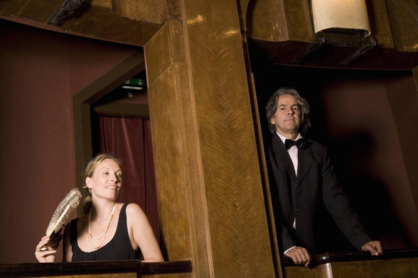 西方人,两个人,露台,站,坐,横图,室内,白天,仰视,衬衫,晚礼服,西装,阳台,剧院,欧洲,欧洲人,握,阴影,套装,正装,反射,领结,扇子,影子,清凉,拿,拿着,注视,职业装,凉爽,文化,观察,看,站着,握着,观看,察看,象征,庄重,关注,身份,正式,地位,羽毛扇,男人,男性,女人,女性,中年男性,中年女性,白种人,站立,坐着,半身,彩图,低角度拍摄,衬衣,晚宴服,舞会服,洋服,洋装,夜礼服,剧场,露天阳台,羽扇,传统文化