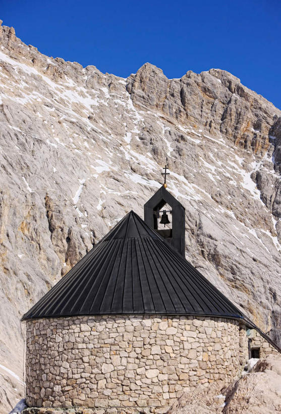 无人,教堂,竖图,室外,白天,仰视,旅游,度假,石头,山,山脉,标志建筑,地标,建筑,德国,欧洲,阴影,节日,光线,石子,影子,山峰,山峦,文化,娱乐,建设,蓝色,蓝天,天空,阳光,群山,天,祈祷,享受,休闲,健康,旅游胜地,放松,许愿,宗教,信仰,晴朗,纪念,祈求,西欧,信念,万里无云,德意志联邦共和国,巴伐利亚,巴伐利亚州,拜恩州,拜恩自由州,楚格峰,平安,石块,岩石,晴空,晴空万里,彩图,低角度拍摄,大教堂,礼拜堂