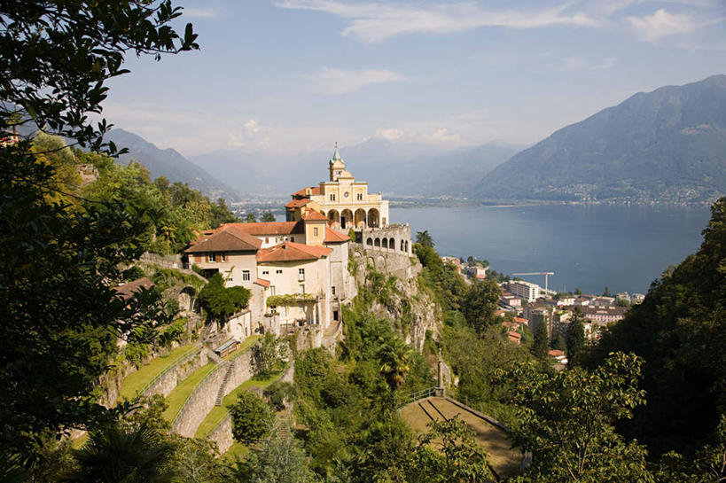 无人,寺庙,横图,室外,白天,正面,旅游,度假,湖,湖泊,名胜古迹,山,山脉,水,植物,标志建筑,地标,建筑,瑞士,欧洲,阴影,节日,遗迹,光线,影子,湖面,山峰,水流,水面,云,云朵,拱门,山峦,燃烧,云彩,古迹,文化,文物,娱乐,建设,古建筑,树,树木,蓝色,绿色,白云,蓝天,天空,阳光,自然,香火,庙宇,湖水,群山,天,祈祷,享受,休闲,健康,旅游胜地,放松,许愿,宗教,信仰,生长,晴朗,成长,纪念,祈求,古文明,中欧,瑞士联邦,提契诺州,洛迦诺,平安,晴空,彩图,庙,寺