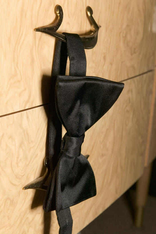 竖图,室内,特写,白天,正面,静物,吊挂,悬挂,领结,墙,挂钩,挂,架子,墙壁,墙面,一个,黑色,单个,半身,彩图