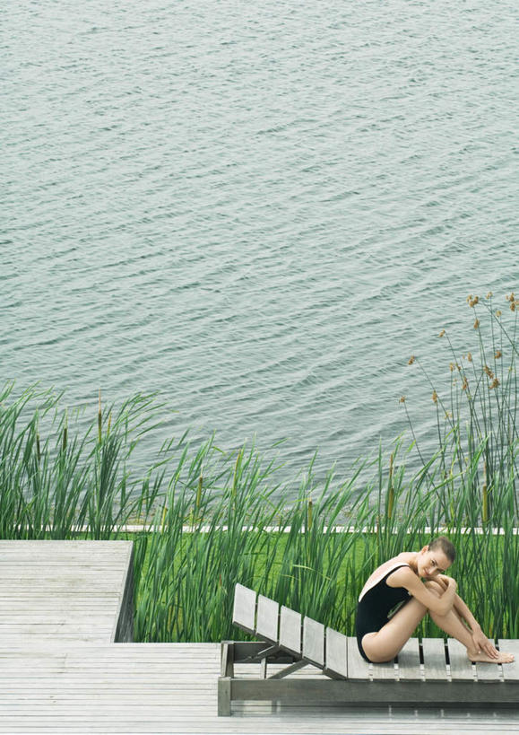 一个人,坐,笑,微笑,竖图,俯视,室外,白天,泳装,比基尼,旅游,度假,草地,草坪,湖,湖泊,水,植物,地板,椅子,仅一个年轻女性,仅一个女性,仅一个人,蜷缩,木椅,躺椅,湖面,水流,水面,地面,注视,娱乐,木地板,草,绿色,湖水,观察,看,享受,休闲,放松,观看,察看,关注,年轻女性,女人,女性,坐着,彩图,高角度拍摄,全身,三点式,泳衣