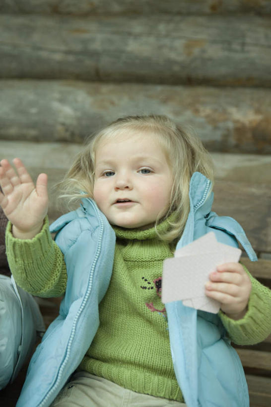 西方人,儿童,一个人,坐,笑,微笑,露齿笑,竖图,室外,白天,正面,毛衣,纯洁,纸牌,玩具,扑克,欧洲,欧洲人,仅一个女性,仅一个人,墙,拿,拿着,注视,墙壁,墙面,小孩,看,招手,仅一个小孩,可爱,童年,童趣,马甲,童真,烂漫,无邪,天真,女孩,女人,女性,白种人,孩子,坐着,半身,彩图,绒衣,套衫,套头毛衣,线衣,女生