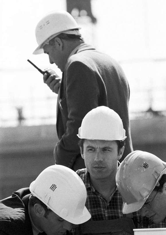 西方人,两个人,伙伴,朋友,工程师,建筑工人,建筑师,工厂,站,说,竖图,黑白,室外,白天,正面,工作服,制服,友谊,合作,团队,帽子,欧洲,欧洲人,朦胧,模糊,眼镜,拿,拿着,注视,安全帽,观察,看,站着,战略,观看,对讲机,察看,关注,近视眼镜,联合,合谋,工作制服,交流,配合,协作,男人,男性,年轻男性,白种人,技师,建筑工,建筑设计师,沟通,讲话,交谈,说话,谈话,站立,半身,工作套服,工地