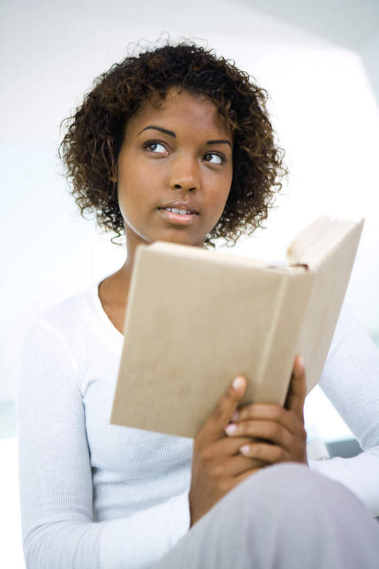 西方人,一个人,客厅,坐,笑,微笑,露齿笑,竖图,室内,白天,正面,沙发,书籍,欧洲,非洲,黑人,欧洲人,仅一个年轻女性,仅一个女性,仅一个人,握,惊讶,拿,拿着,注视,观察,看,靠,靠着,握着,观看,遥望,察看,起居室,关注,布艺沙发,渴望,年轻女性,女人,女性,非洲人,书,图书,坐着,半身,彩图