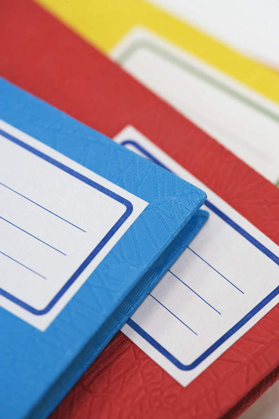 无人,竖图,俯视,室内,特写,白天,桌子,一堆,堆叠,堆积,朦胧,模糊,记事本,书桌,三个,黄色,红色,蓝色,本子,笔记本,课桌,三本,堆,标贴,彩图,高角度拍摄