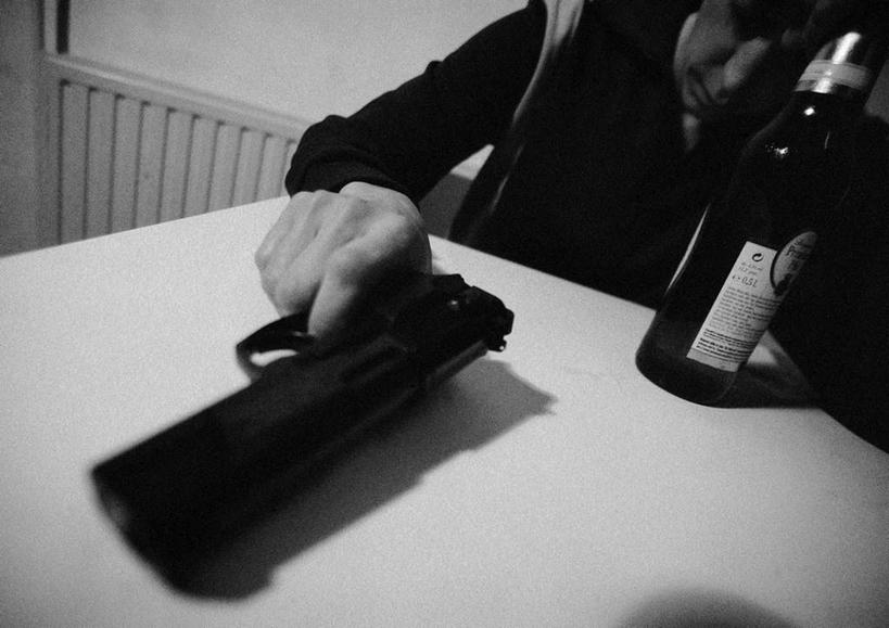 西方人,一个人,坐,竖图,俯视,黑白,室内,白天,竞争,桌子,欧洲,欧洲人,仅一个男性,仅一个人,一把,对抗,握,朦胧,模糊,冲突,枪,拿,拿着,破坏,玻璃制品,酒瓶,仅一个年轻男性,玻璃瓶,瓶子,武器,战争,握着,手枪,损坏,攻击,威胁,对立,矛盾,兵器,防御,敌对,挫败,斗争,抗拒,抗衡,杀伤,威慑,危险,男人,男性,年轻男性,白种人,坐着,半身,高角度拍摄