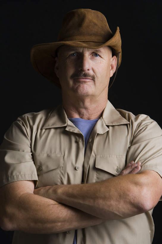 西方人,胡须,一个人,站,双手交叉,竖图,室内,白天,正面,帽子,欧洲,欧洲人,仅一个男性,仅一个人,仅一个中年男性,黑色背景,服装,注视,休闲装,衣服,观察,看,站着,休闲,休闲服,牛仔帽,摄影,服饰,影棚,观看,察看,双手抱胸,关注,一顶,男人,男性,中年男性,白种人,胡子,小胡子,站立,半身,彩图,影棚拍摄,拍摄