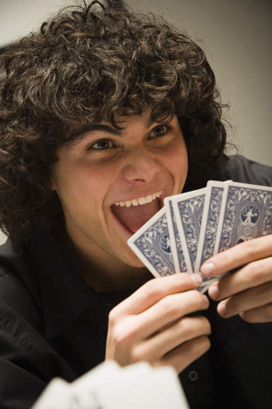 西方人,脸,头,脸颊,手,头发,一个人,坐,笑,微笑,露齿笑,竖图,室内,特写,白天,正面,游戏,赌博,贪欲,竞争,扑克牌,纸牌,玩具,扑克,欧洲,欧洲人,双手,仅一个男性,仅一个人,握,阴影,服装,反射,影子,玩,注视,休闲装,娱乐,刺激,肩膀,仅一个年轻男性,衣服,黑色,观察,看,休闲,手部,休闲服,握着,服饰,观看,活动,察看,发泄,关注,消遣,智力,赌具,投机,侥幸,欲望,宣泄,男人,男性,年轻男性,白种人,头部,卷发,脸部,脸蛋,面部,玩耍,嬉戏,坐着,半身,彩图,胜负,输赢,短发