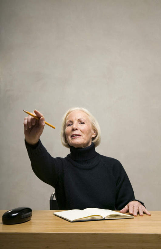 西方人,头发,一个人,坐,竖图,室内,白天,正面,毛衣,桌子,欧洲,欧洲人,仅一个女性,仅一个人,握,指,灰色背景,笔,墙,记事本,拿,拿着,注视,方向,书桌,墙壁,墙面,白色,黑色,本子,笔记本,课桌,观察,看,手势,握着,摄影,仅一个老年女性,影棚,观看,察看,指向,关注,眼镜盒,老年女性,女人,女性,白种人,坐着,半身,彩图,影棚拍摄,绒衣,套衫,套头毛衣,线衣,拍摄