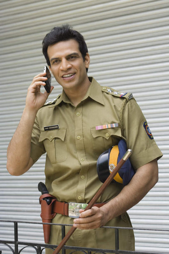 一个人,交警,栏杆,站,笑,打电话,微笑,露齿笑,竖图,室内,白天,正面,工作服,制服,电话,手机,亚洲,仅一个男性,仅一个人,服装,围栏,拿,拿着,注视,休闲装,通讯设备,护栏,仅一个年轻男性,衣服,绿色,观察,看,站着,休闲,休闲服,服饰,观看,察看,关注,工作制服,交流,男人,男性,年轻男性,亚洲人,印度人,交通管理员,交通警察,沟通,通话,站立,半身,彩图,工作套服