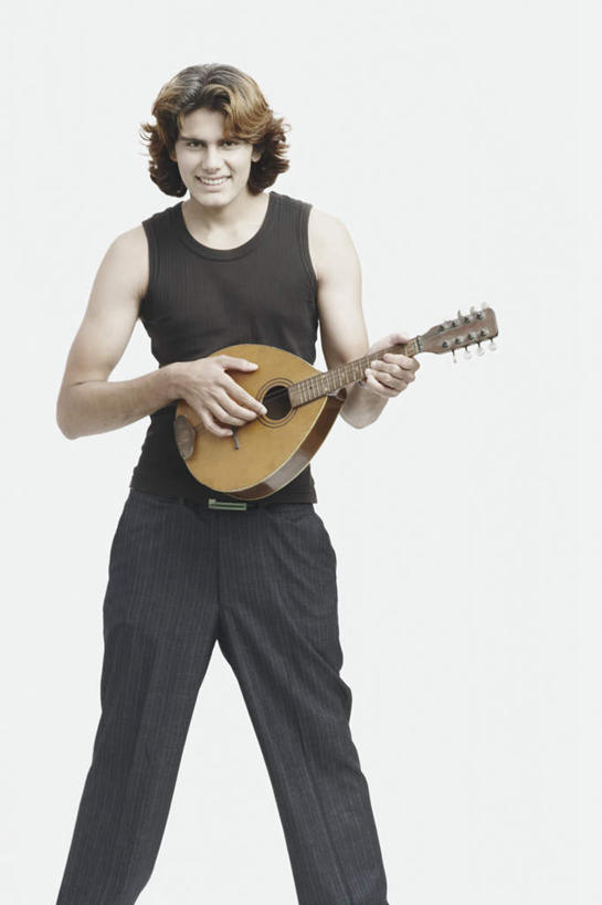 一个人,站,笑,微笑,露齿笑,竖图,室内,白天,白色背景,正面,亚洲,仅一个男性,仅一个人,握,服装,褐色,乐器,弦乐器,弹奏,拿,拿着,注视,休闲装,腰带,仅一个年轻男性,衣服,观察,看,站着,休闲,休闲服,握着,摄影,服饰,影棚,观看,皮带,察看,关注,弹拨弦鸣乐器,配饰,裤带,班卓琴,男人,男性,年轻男性,亚洲人,印度人,站立,半身,彩图,影棚拍摄,拍摄,弹拨弦乐器