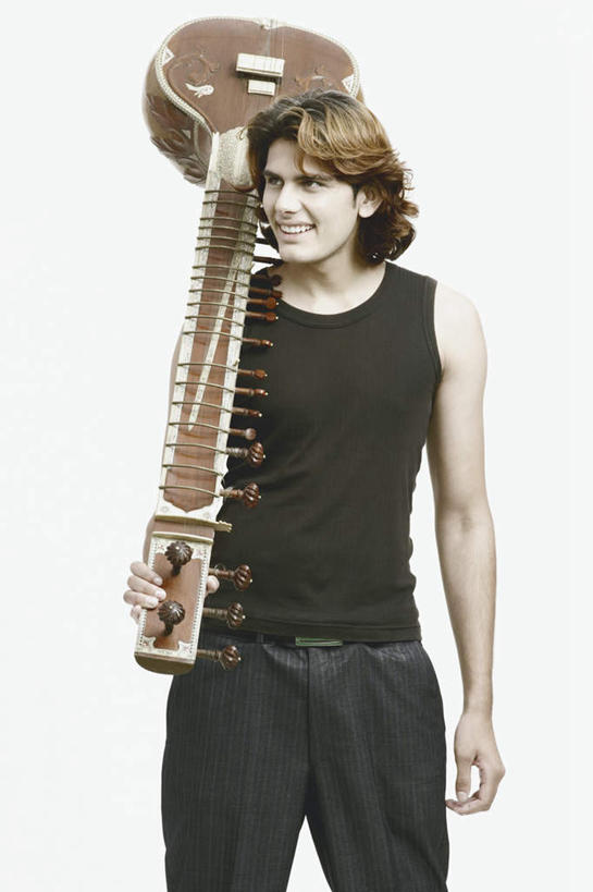 一个人,站,笑,微笑,露齿笑,竖图,室内,白天,白色背景,正面,亚洲,仅一个男性,仅一个人,握,服装,褐色,乐器,弦乐器,拿,拿着,注视,休闲装,腰带,仅一个年轻男性,衣服,观察,看,站着,休闲,休闲服,握着,摄影,服饰,影棚,观看,皮带,察看,关注,弹拨弦鸣乐器,配饰,裤带,班卓琴,男人,男性,年轻男性,亚洲人,印度人,站立,半身,彩图,影棚拍摄,拍摄,弹拨弦乐器