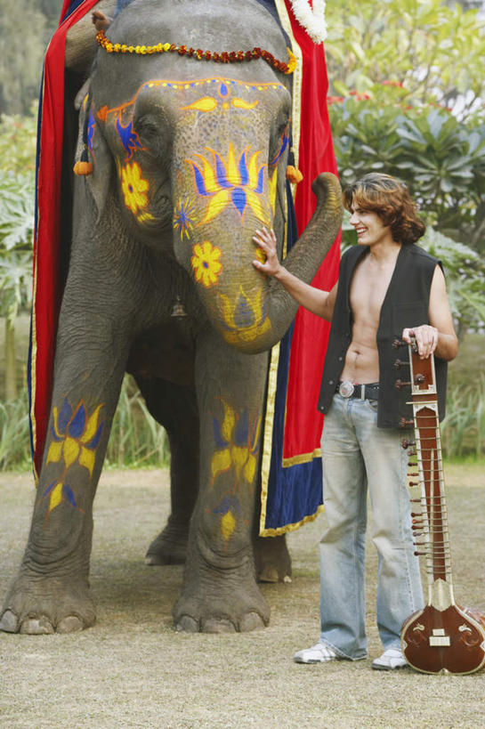 西方人,一个人,站,笑,摸,微笑,露齿笑,竖图,室外,白天,正面,树林,植物,靠垫,大象,野生动物,欧洲,欧洲人,仅一个男性,仅一个人,抚摸,花纹,服装,节日,艺术,彩绘,花环,图案,靠枕,乐器,弦乐器,休闲装,文化,树,树木,仅一个年轻男性,一个,衣服,绿色,白色,自然,动物,垫子,枕头,祈祷,站着,休闲,健康,休闲服,可爱,许愿,宗教,服饰,信仰,活泼,生长,成长,纪念,华丽,祈求,弓拉弦乐器,弓拉弦鸣乐器,凶猛,人体彩绘,印度文化,美观,西塔尔,西塔琴,纹身彩绘,锡塔尔琴,平安,男人,男性,年轻男性,白种人,触摸,接触,站立,彩图,全身