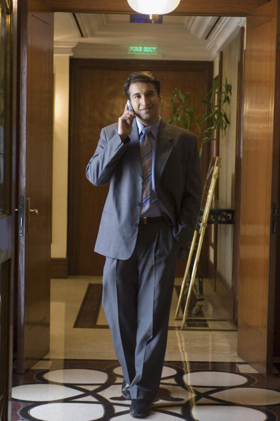 一个人,走,笑,打电话,微笑,竖图,室内,白天,正面,衬衫,西装,电话,手机,亚洲,仅一个男性,仅一个人,仅一个中年男性,套装,正装,领带,职业装,通讯设备,交流,男人,男性,中年男性,亚洲人,印度人,步行,插兜,沟通,散步,手插兜,手放口袋,通话,走路,彩图,全身,衬衣