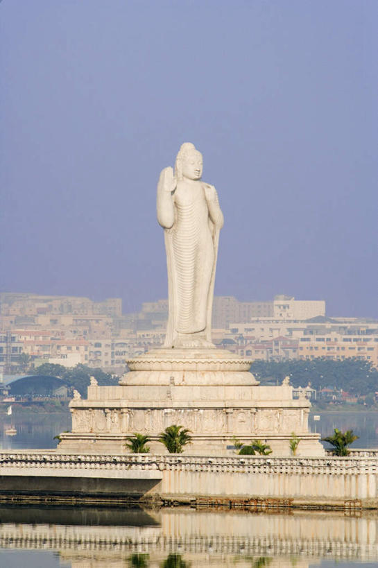 一个人,无人,站,举,竖图,室外,白天,仰视,民族服装,旅游,度假,名胜古迹,标志建筑,地标,建筑,雕塑,印度,亚洲,仅一个男性,仅一个人,仅一个中年男性,朦胧,模糊,遗迹,艺术,装饰,雕刻,雕像,挥手,注视,古迹,文物,娱乐,建设,再见,古建筑,石雕,蓝色,蓝天,天空,工艺品,天,观察,看,手势,托,站着,招手,享受,休闲,旅游胜地,放松,晴朗,告别,观看,纪念,美术,察看,关注,主题,南亚,摆动,陈列,古文明,离别,万里无云,首府,印度共和国,功能,美学,辞行,安得拉,安得拉邦,海得拉巴,海德拉巴,男人,男性,中年男性,亚洲人,印度人,晴空,晴空万里,举起,举手,举着,向上举,向上伸,向上托,站立,彩图,低角度拍摄,全身,传统服装,民俗服