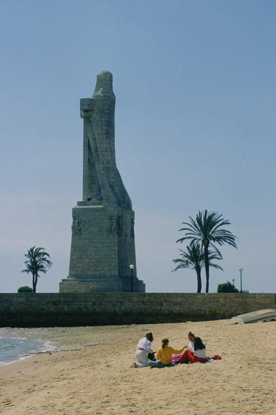 西方人,三个人,伙伴,朋友,坐,竖图,室外,白天,正面,旅游,度假,友谊,沙滩,植物,标志建筑,地标,建筑,棕榈树,叶子,雕塑,西班牙,欧洲,欧洲人,阴影,服装,艺术,装饰,光线,雕刻,雕像,沙子,影子,海岸,绿叶,沙地,注视,休闲装,娱乐,建设,树,树木,衣服,蓝色,绿色,蓝天,天空,阳光,自然,工艺品,天,观察,看,享受,休闲,休闲服,嫩叶,旅游胜地,放松,服饰,生长,晴朗,成长,观看,纪念,美术,察看,关注,南欧,主题,陈列,棕榈叶,万里无云,西班牙王国,功能,美学,哥伦布,航海家,探险家,友情,男人,男性,年轻男性,年轻女性,女人,女性,白种人,叶,叶片,海滩,晴空,晴空万里,坐着,彩图,全身,克里斯托弗.哥伦布