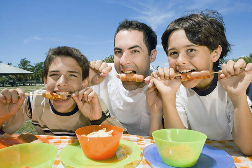 西方人,儿童,中年人,三个人,家庭,父亲,儿子,坐,笑,吃,微笑,露齿笑,横图,室外,白天,正面,纯洁,草地,草坪,植物,桌面,桌子,餐具,欧洲,欧洲人,握,阴影,服装,光线,木制,布料,碟子,盘,影子,陶瓷,云,云朵,调料,酱料,酱汁,茄汁,肉,香肠,佐料,陶瓷制品,腊肠,调味品,拿,调味料,云彩,布纹,拿着,注视,休闲装,番茄酱,猪肉,酱,肉类,竹签,桌布,草,树,树木,小孩,衣服,蓝色,绿色,白云,蓝天,天空,阳光,自然,盘子,餐巾,木制品,容器,碟,台布,碗,天,观察,看,休闲,温暖,温馨,父子,一家人,休闲服,父爱,可爱,童年,童趣,握着,服饰,生长,晴朗,成长,观看,储藏,和睦,察看,储存,关注,肉食,童真,烂漫,无邪,豚肉,取食签,天真,男孩,男人,男性,中年男性,白种人,孩子,晴空,嚼,食,坐着,半身,彩图,融洽,贮存,男生