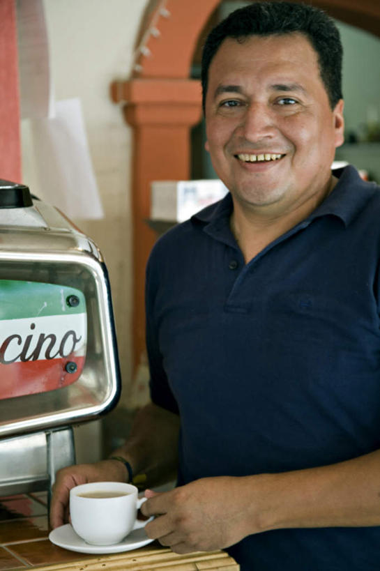 咖啡,西方人,一个人,餐厅,站,笑,微笑,露齿笑,竖图,室内,白天,正面,幸福,桌面,桌子,杯子,餐具,欧洲,欧洲人,仅一个男性,仅一个人,仅一个中年男性,阴影,服装,时间,反射,木制,英文,标志,瓷器,电器,碟子,工具,盘,时钟,手表,文字,影子,字符,字母,墙,咖啡杯,陶瓷制品,计时,注视,休闲装,娱乐,设备,标识,墙壁,墙面,饮料,一个,衣服,白色,盘子,木制品,碟,钟表,观察,看,站着,享受,休闲,温馨,休闲服,表,放松,乐趣,冲泡,搭,服饰,单个,观看,英文字母,腕表,察看,提神,舒适,家电,家用电器,咖啡机,搭着,关注,磨粉,瓷杯,醒脑,软饮料,店东,店主,东主,男人,男性,中年男性,白种人,钟,站立,半身,彩图,餐馆,饭店,饭馆,清除,压粉,装粉