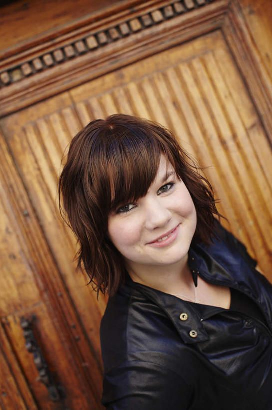 一个人,站,笑,微笑,露齿笑,竖图,俯视,室内,白天,门,仅一个年轻女性,仅一个女性,仅一个人,服装,墙,注视,休闲装,墙壁,墙面,衣服,门框,观察,看,站着,休闲,休闲服,服饰,观看,察看,关注,皮衣,年轻女性,女人,女性,站立,半身,彩图,高角度拍摄